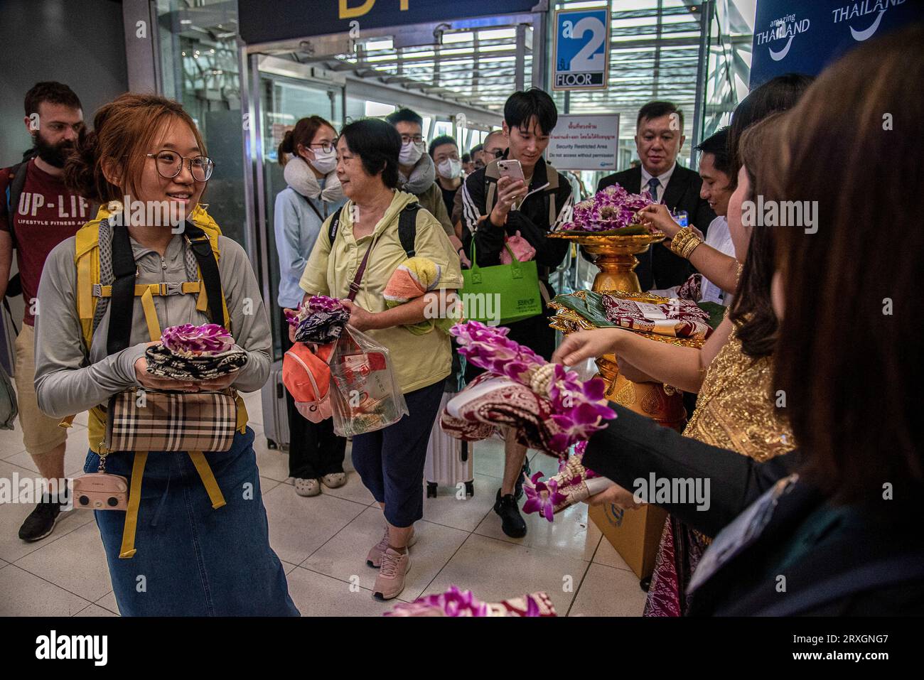 Samut Prakarn, Thailand. 25th Sep, 2023. Chinese tourists receive souvenirs from Thai officials after arriving at the Suvarnabhumi International Airport during a welcoming ceremony to mark the first day of the government's visa-free scheme. In an attempt to boost tourism, starting Sept. 25, the Thailand government is granting Chinese and Kazakh tourists a temporary visa exemption for 30-day visits. The waiver is due to expire at the end of February. (Photo by Peerapon Boonyakiat/SOPA Images/Sipa USA) Credit: Sipa USA/Alamy Live News Stock Photo