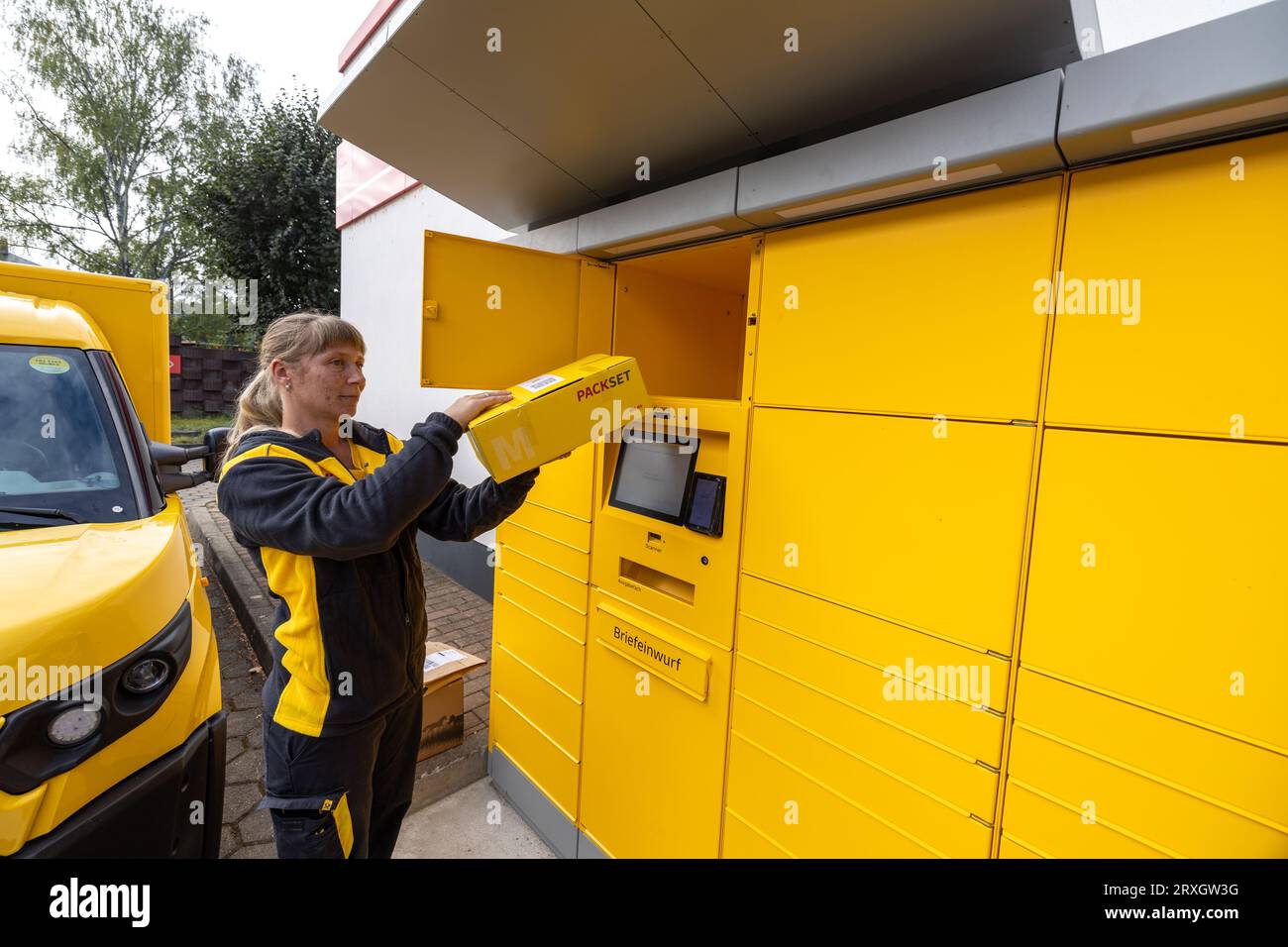 25 September 2023, Saxony, Meißen: A Deutsche Post AG postwoman removes a parcel (returned items) at a postal station in Meißen, Saxony. In addition to parcels, letters can also be posted at this location. Photo: Daniel Schäfer/dpa Stock Photo