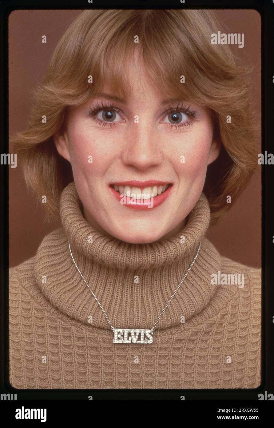 A 1979 posed portrait of a beautiful model wearing an Elvis necklace. Stock Photo