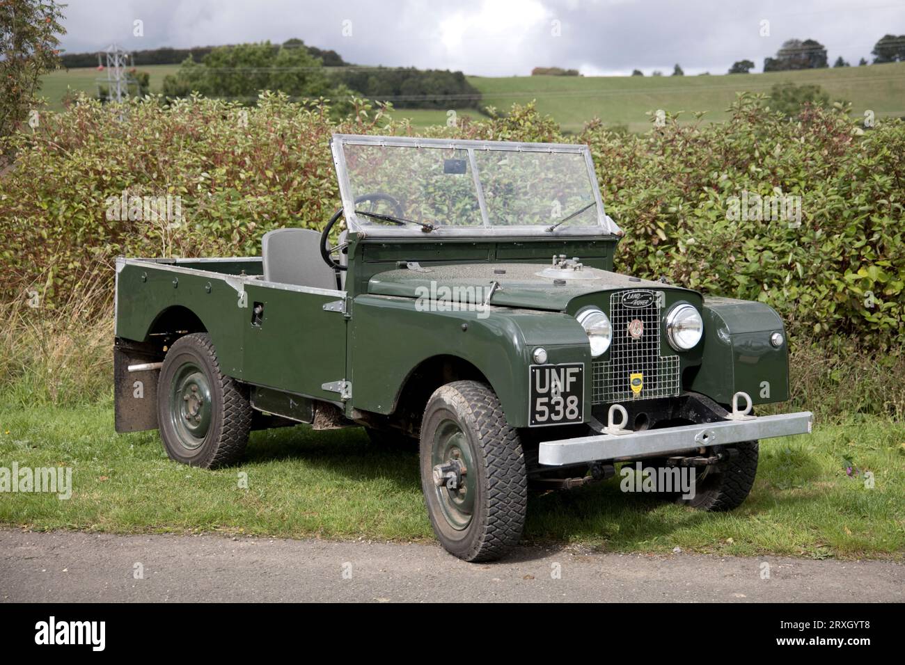 Fully restored 1956 green Series 1 Landrover parked on grass in front of hedge Colemans Hill Farm Mickleton Chipping Campden UK Stock Photo