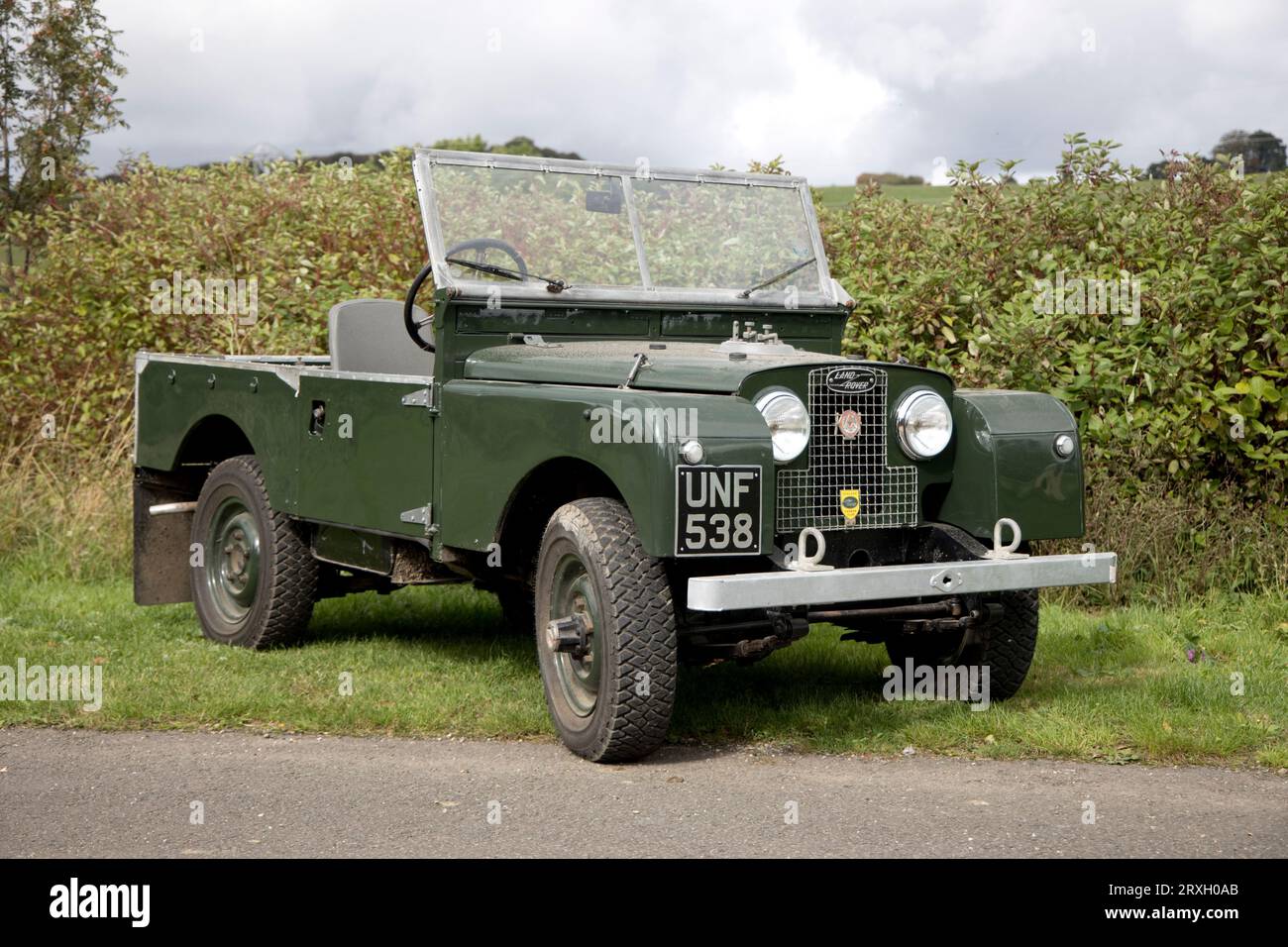 Fully restored 1956 green Series 1 Landrover parked on grass in front of hedge Colemans Hill Farm Mickleton Chipping Campden UK Stock Photo