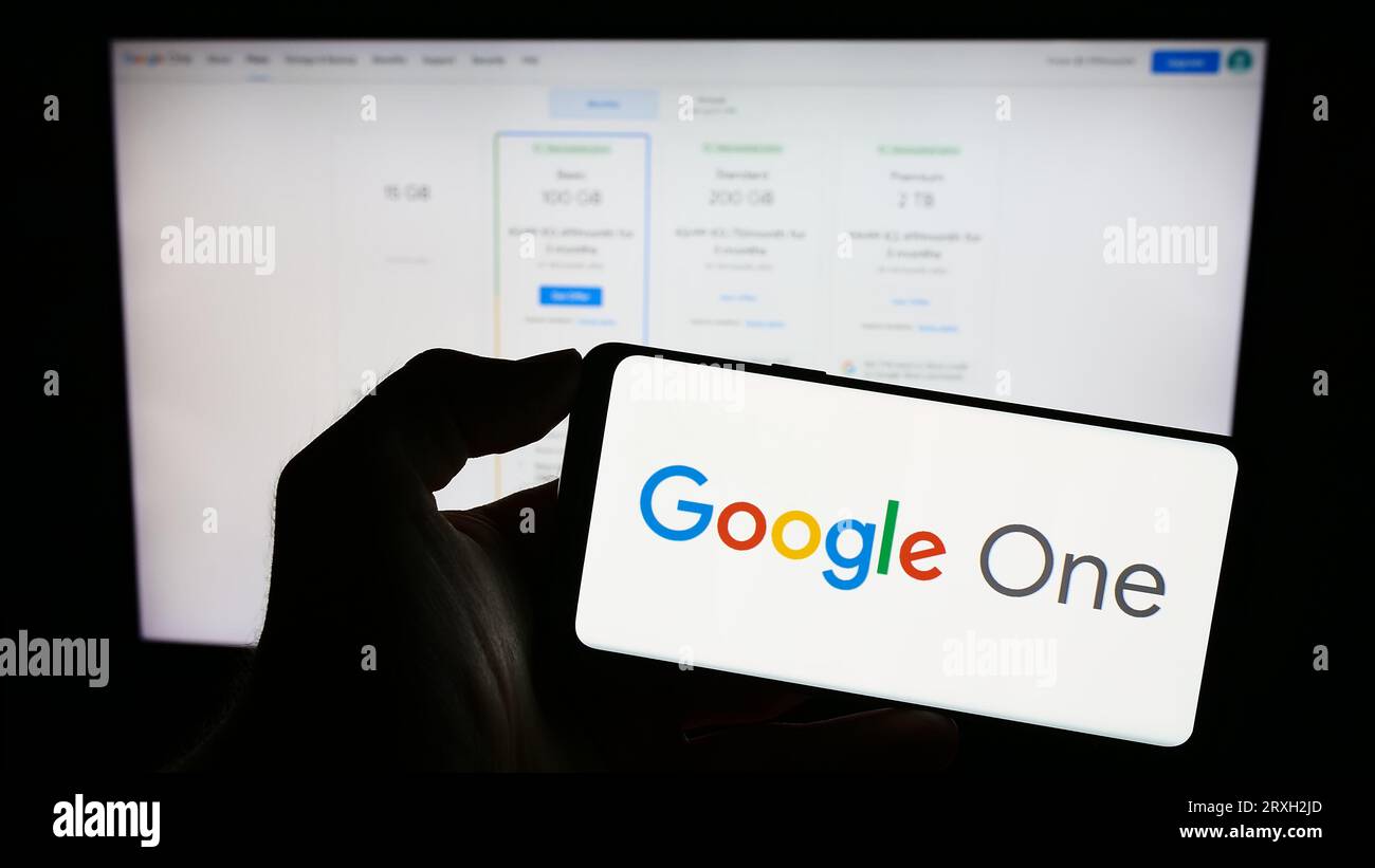 Person holding mobile phone with logo of software subscription service ...