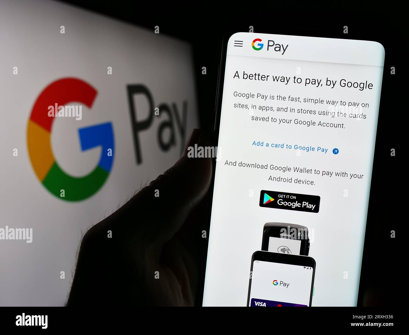 Person holding smartphone with webpage of mobile payment service Google Pay on screen in front of logo. Focus on center of phone display. Stock Photo