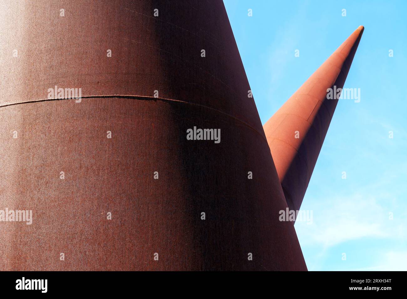 Rusty metal geometric cone shapes on sky blue background Stock Photo ...
