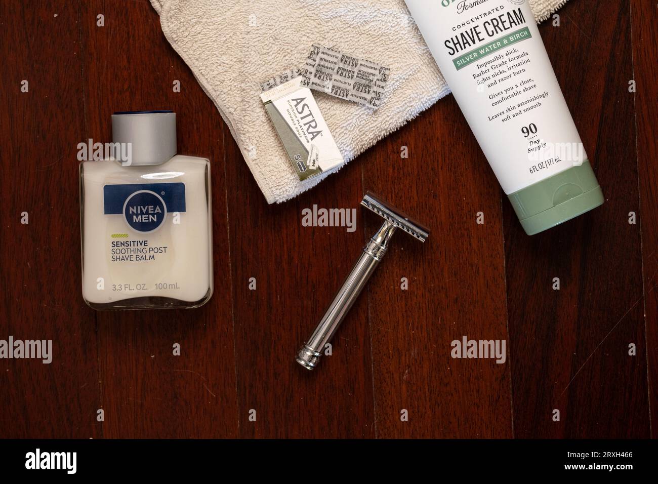 Flat lay of men's beard shaving items double-edge razor, razor blades, shave cream, face balm and towel Stock Photo