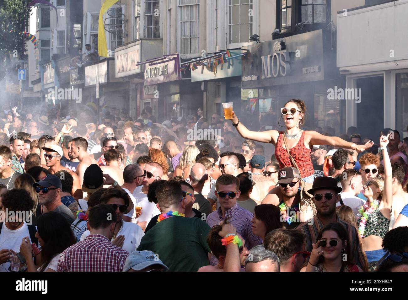 Brighton and Hove, United Kingdom, August 5 2018: Woman with pint of beer lifted above crowd during annual Pride celebrations Stock Photo