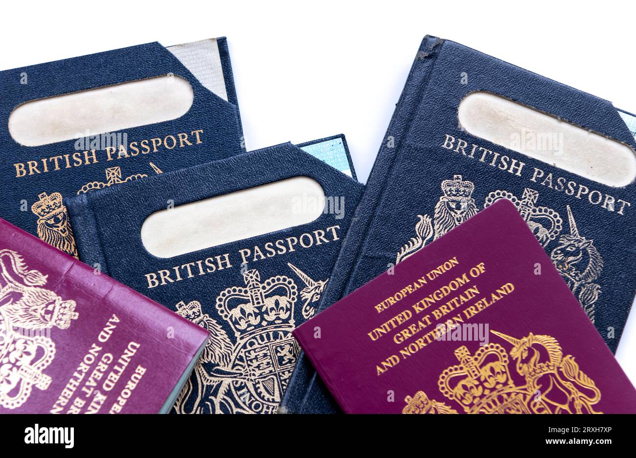 Close up of expired and current British passport spanning fifty years isolated in a white background. Stock Photo