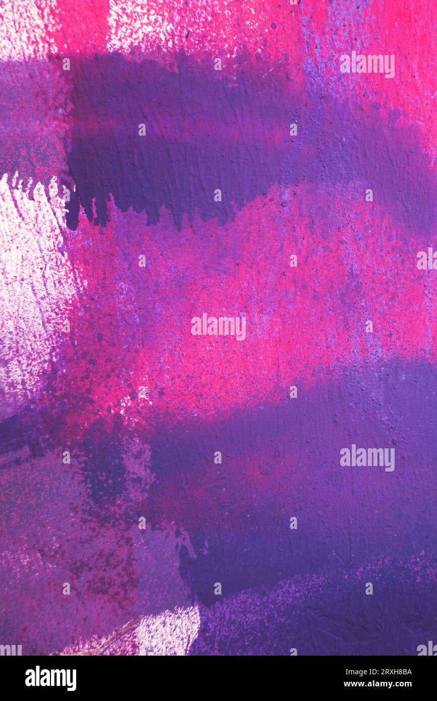 Purple paint strokes and smudges on an pink painted wall background ...