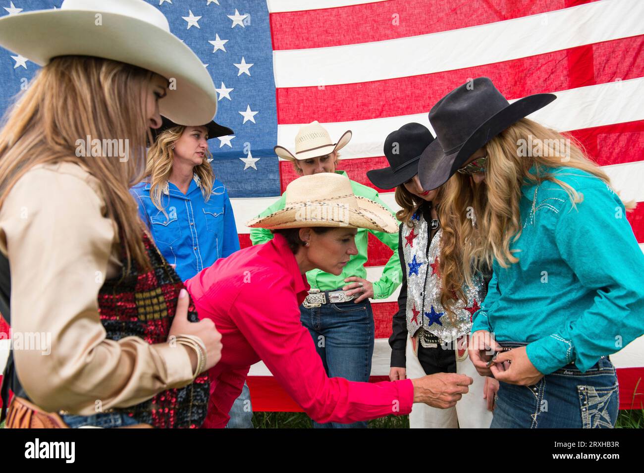 Rodeo queens in front of an American flag; Burwell, Nebraska, United States of America Stock Photo