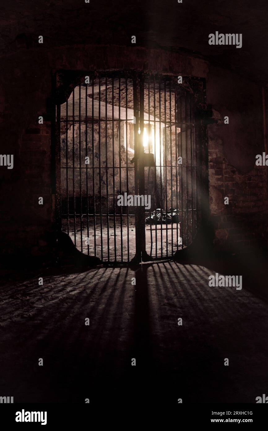 Light glowing from Iron grate in old cellar. Stock Photo