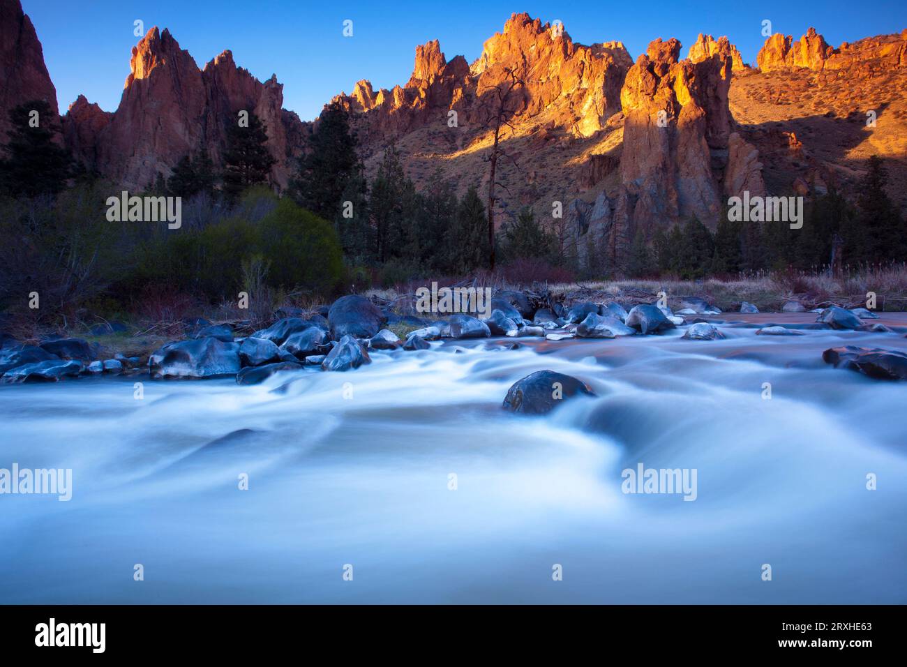 Motion blur of the current of the Crooked River running in the foreground through the rugged landscape in Smith Rock State Park of Oregon, USA Stock Photo