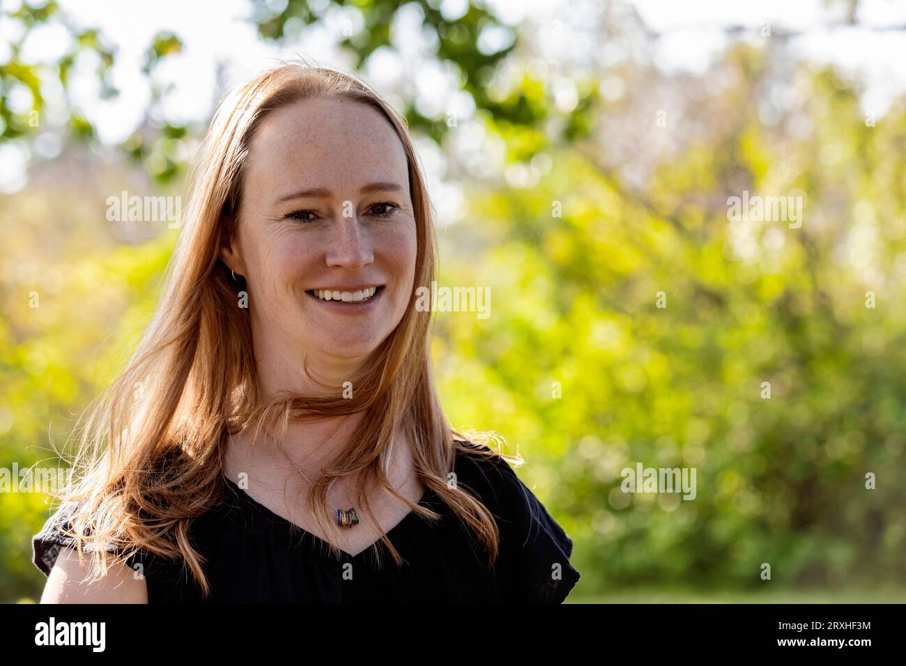 Outdoor portrait of a beautiful woman in a city park during a warm fall