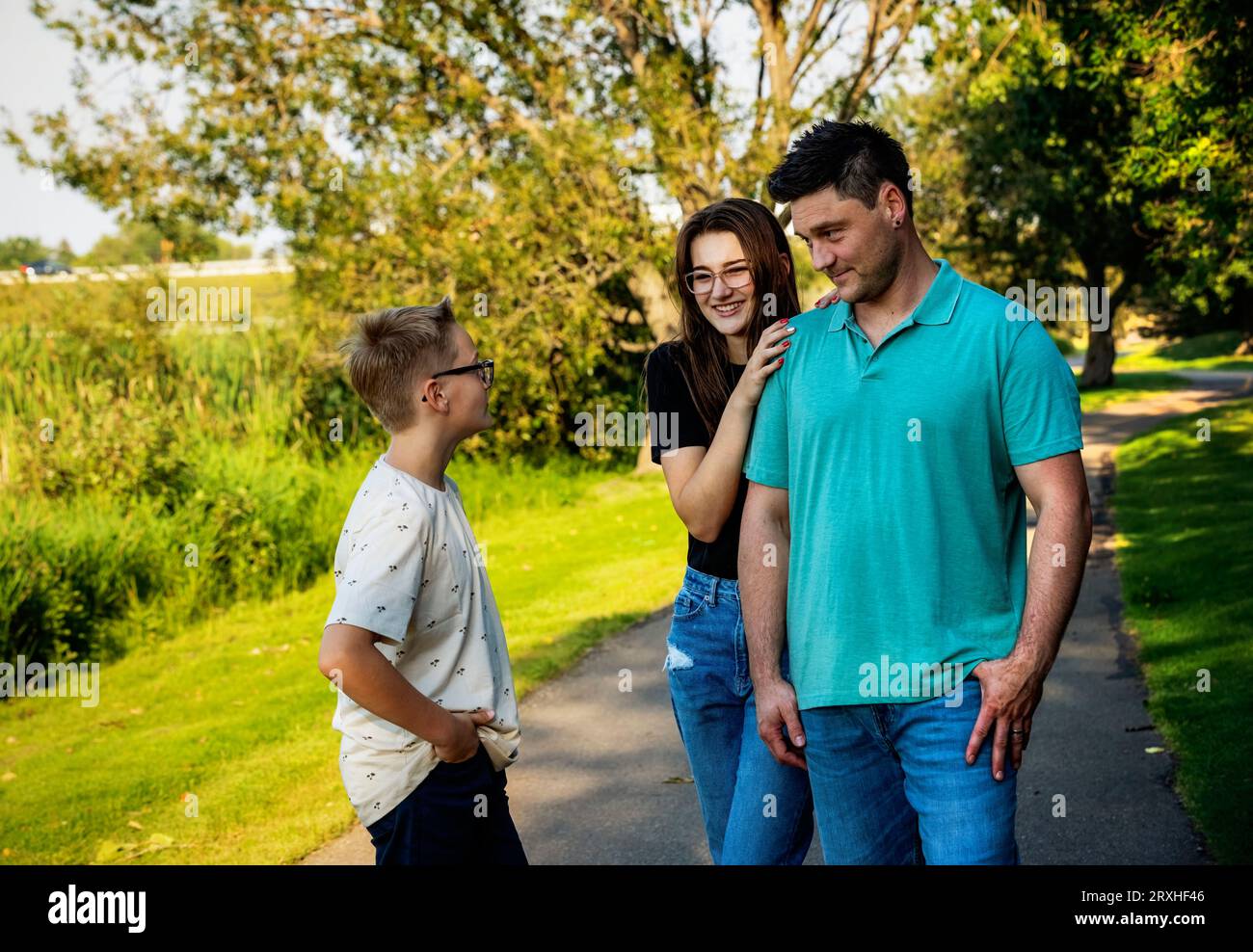 Father spending quality time outdoors with his teenage children, in a city park during a warm fall afternoon; Leduc, Alberta, Canada Stock Photo