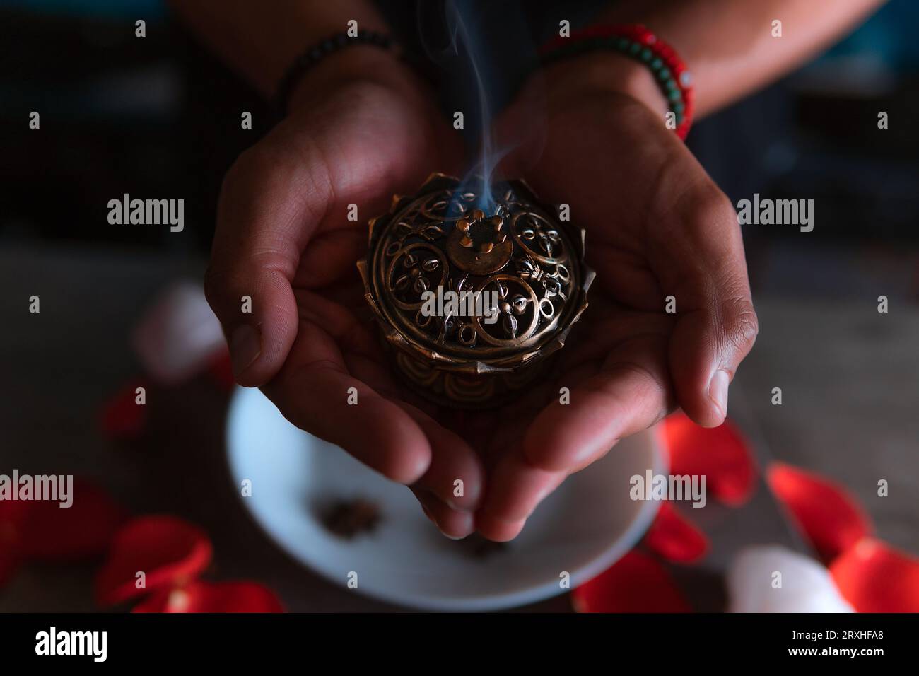 Close-up of hands lighting an incense, witch on the day of the dead performing a cleansing ritual, Halloween, spiritual beliefs, white magic Stock Photo