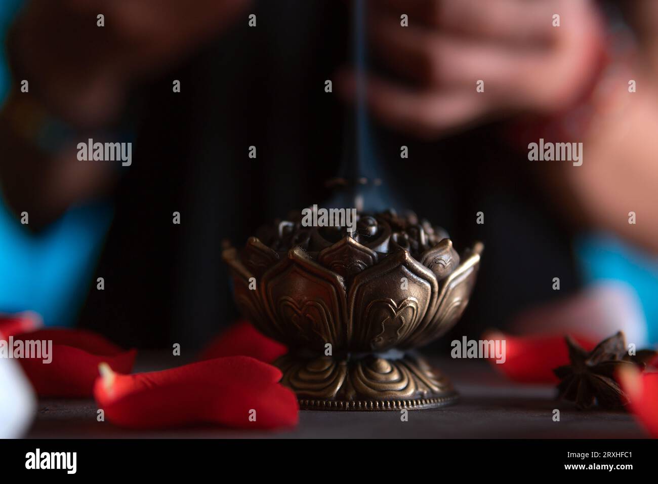 Close-up of hands lighting an incense, witch on the day of the dead performing a cleansing ritual, Halloween, spiritual beliefs, white magic Stock Photo