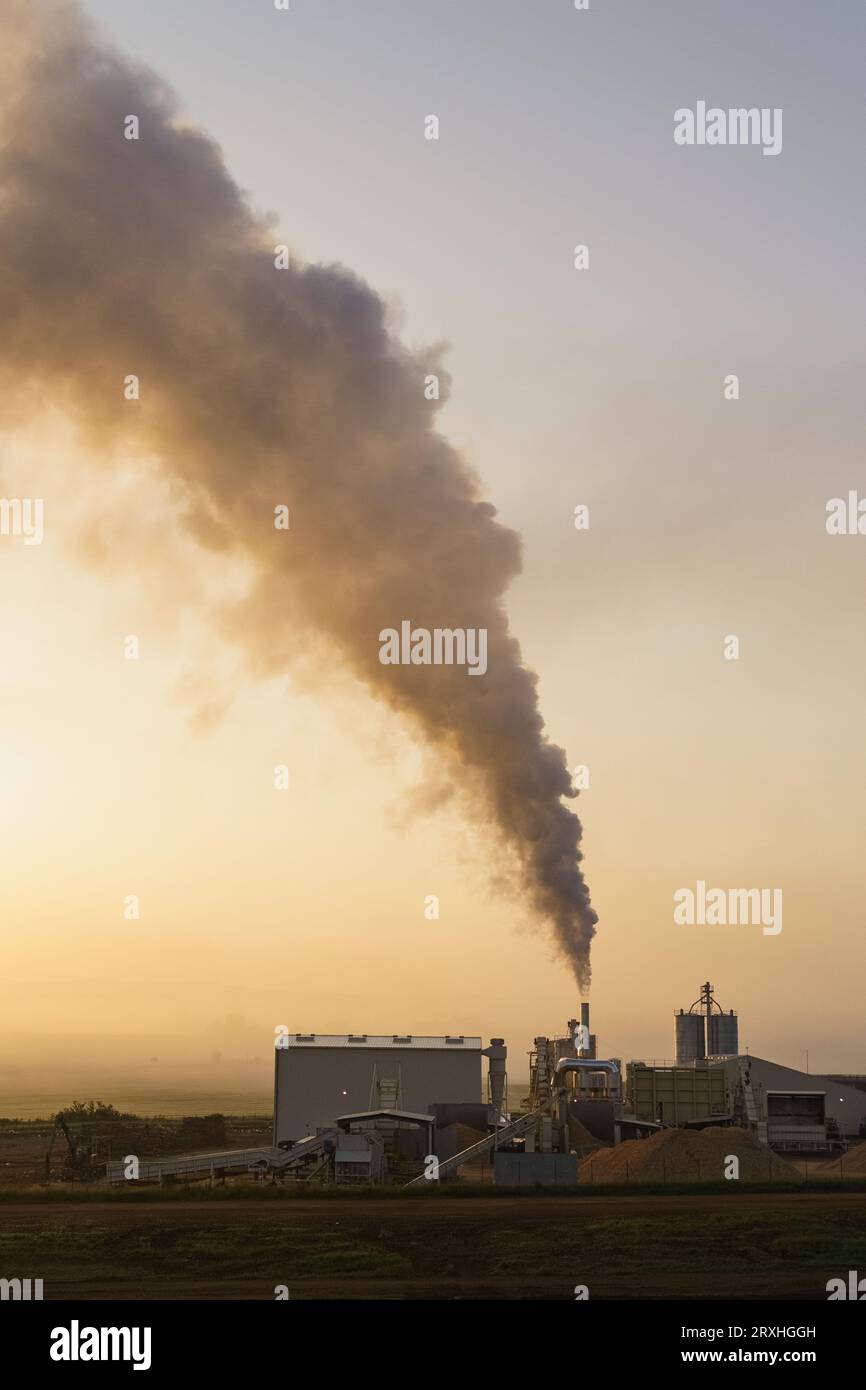 View of a high chimney with smoke ejection. Factory pipes pollute the atmosphere. Stock Photo