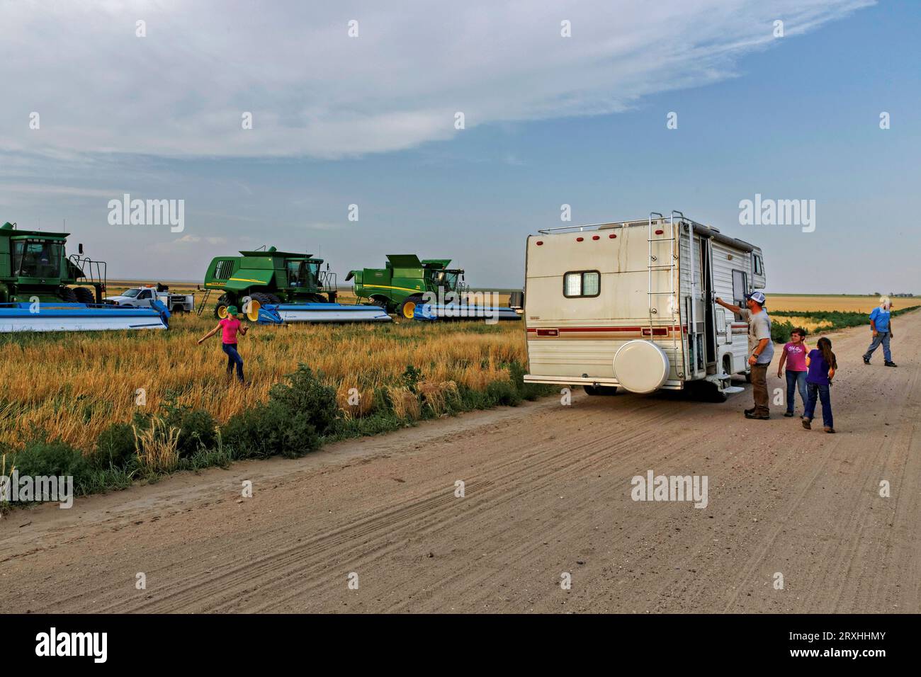 A family parks an RV in the field during the harvest so they can escape