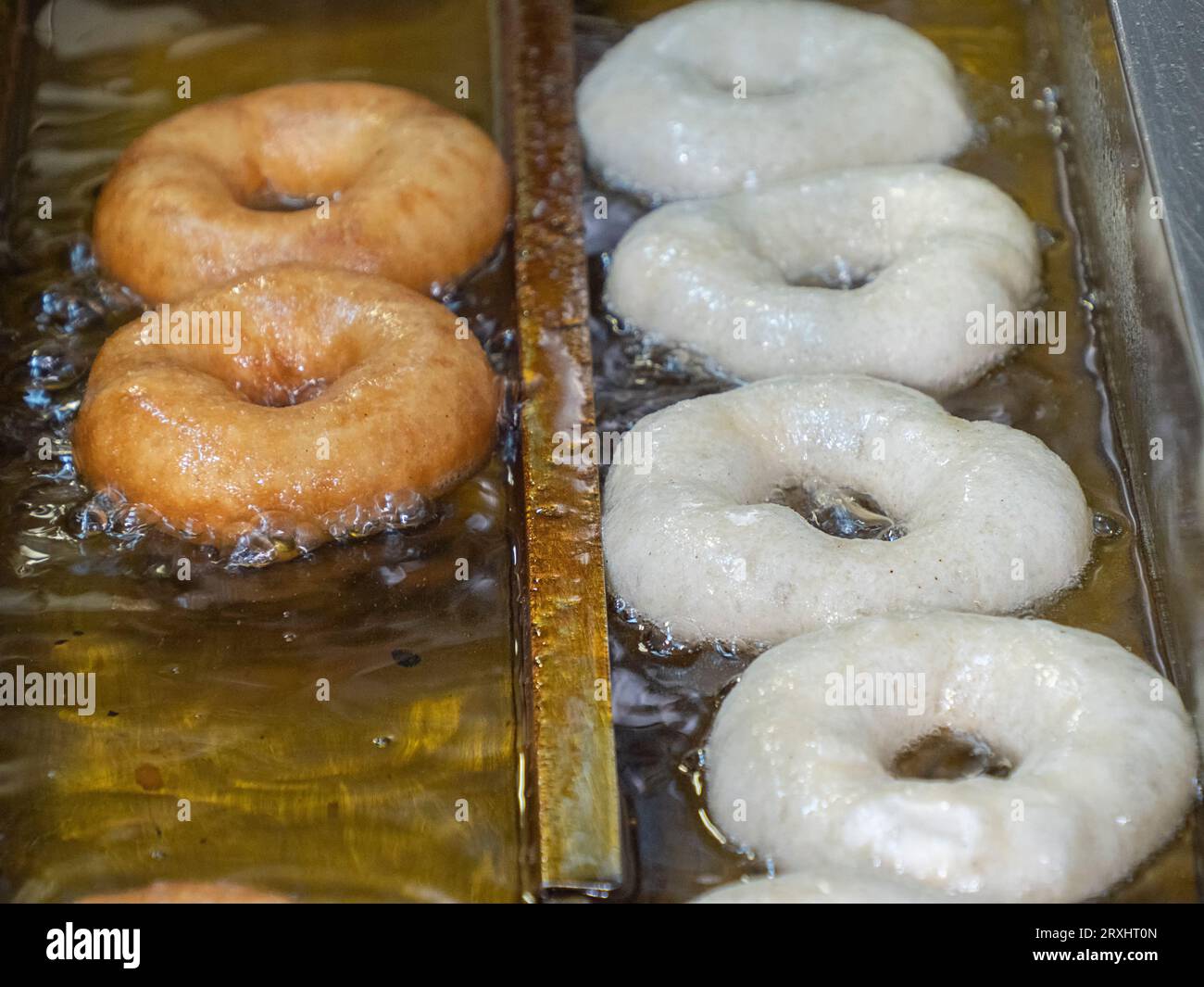 Cooking of the fried sweet tasty doughnuts in deepfryer hot oil Stock