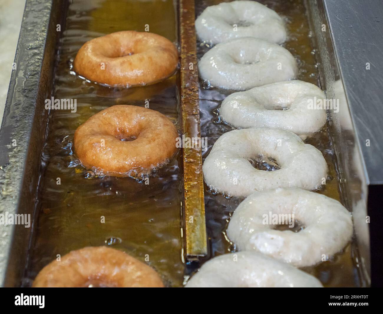 Cooking of the fried sweet tasty doughnuts in deepfryer hot oil Stock Photo Alamy