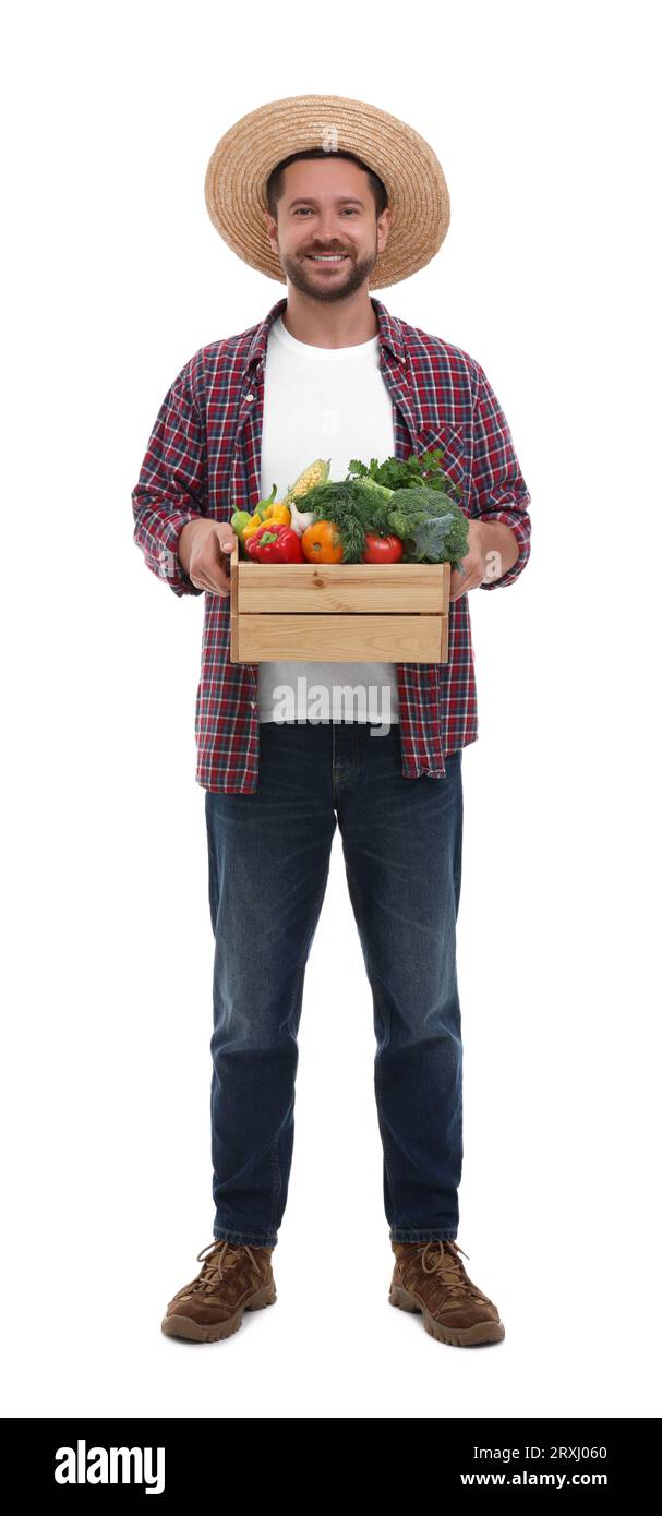 Harvesting season. Happy farmer holding wooden crate with vegetables on ...