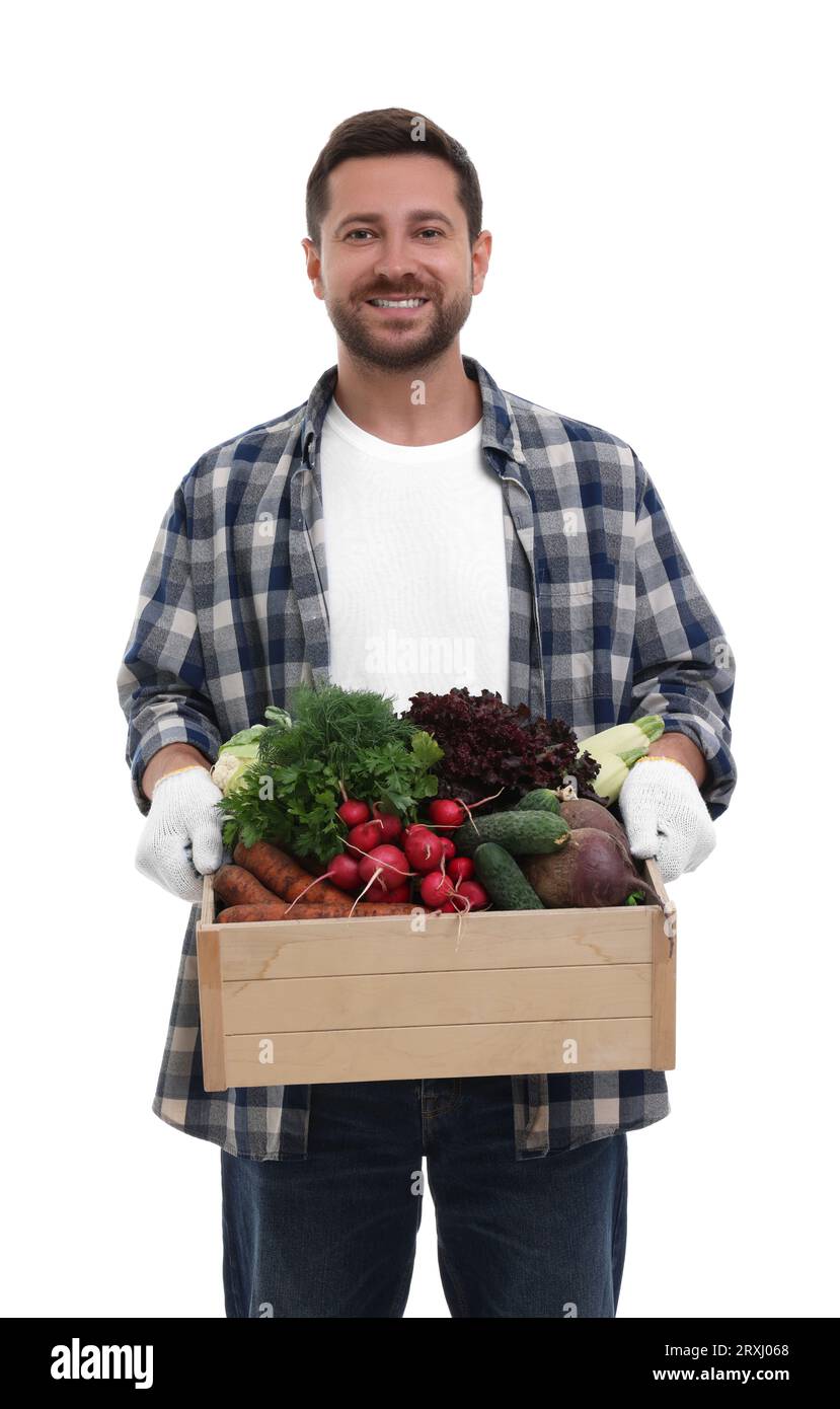 Harvesting season. Happy farmer holding wooden crate with vegetables on ...