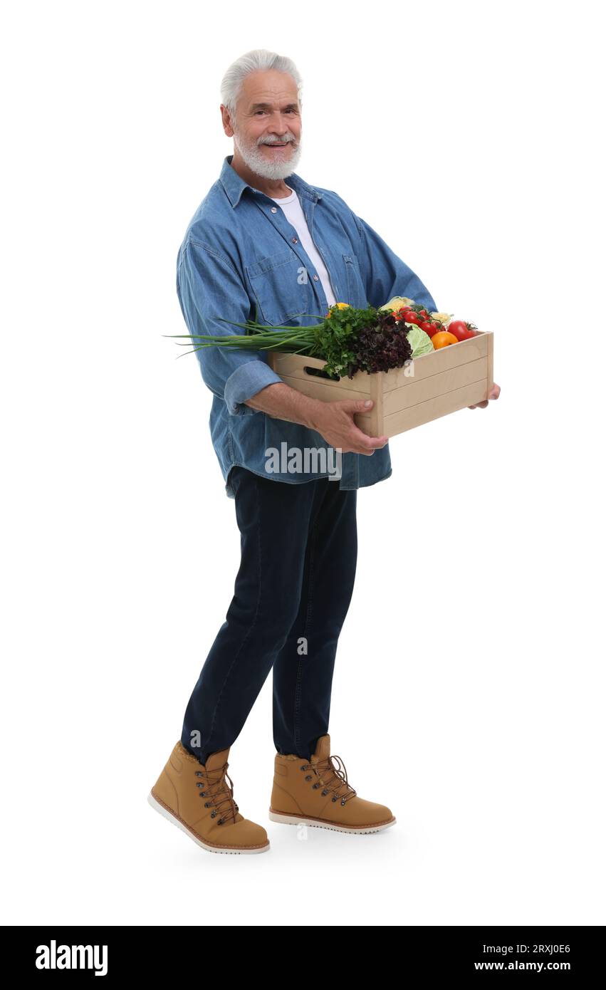 Harvesting season. Happy farmer holding wooden crate with vegetables on ...