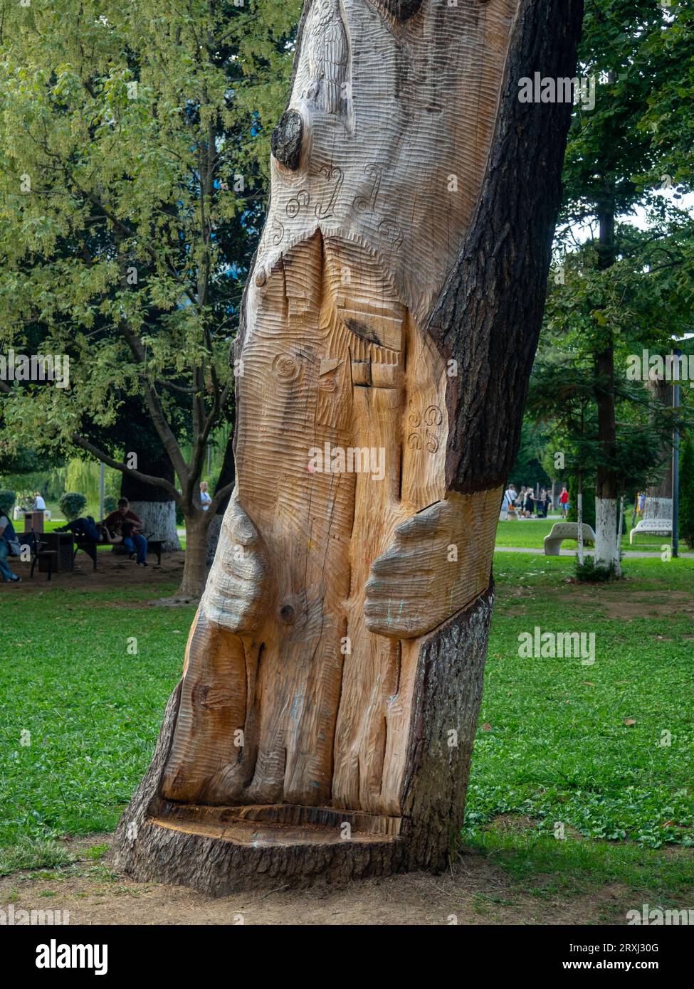 Carved picture on a tree in the park. Decorating a dead tree. Decoration of a public place. Landscaping. Dead tree in the park. Stock Photo