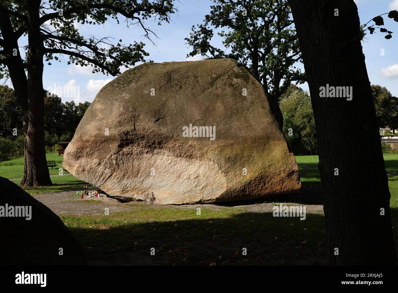 Altentreptow, Germany. 25th Sep, 2023. The 'Big Stone', a huge boulder, where often stayed the 13-year-old girl who died three months ago after consuming an ecstasy pill 'Blue Punisher'. Flowers, pictures, candles and grave lights commemorate her. The girl allegedly took the drug in mid-June. She had been brought to a clinic unconscious and died in late June. Three months after drug death, investigation still ongoing Credit: Bernd Wüstneck/dpa/Alamy Live News Stock Photo