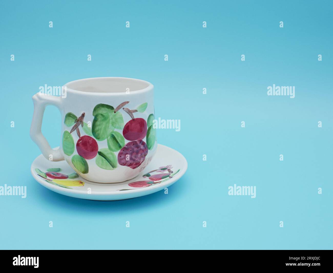 vintage cup of tea with saucer isolated on blue background. Antique tea cup with flower pattern asian style Stock Photo