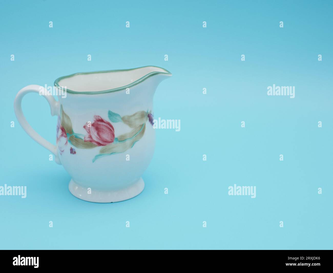 vintage cup of tea isolated on blue background. Antique tea cup with flower pattern asian style Stock Photo