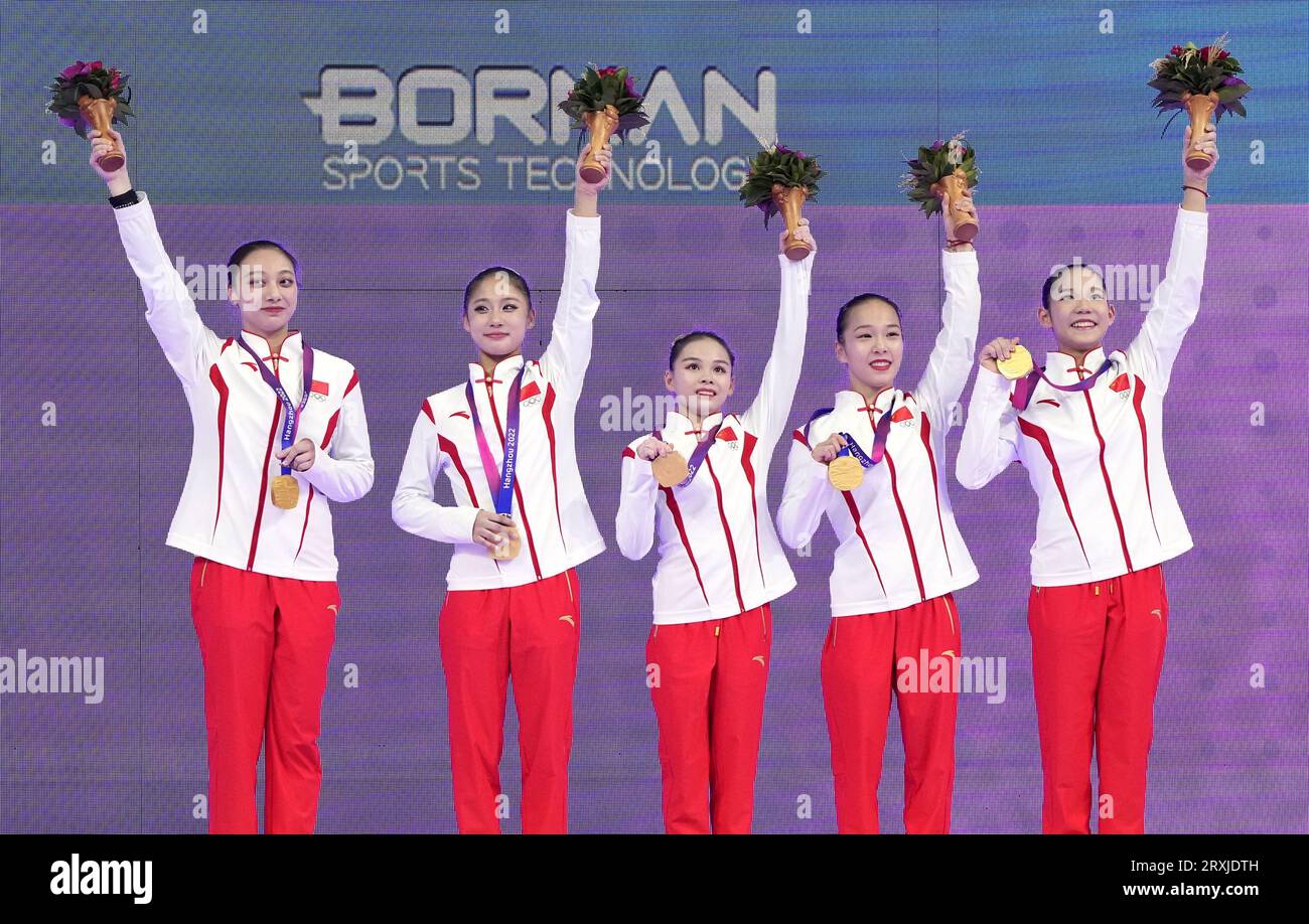 Members of the Chinese artistic gymnastics team pose for photos after winning gold in the women