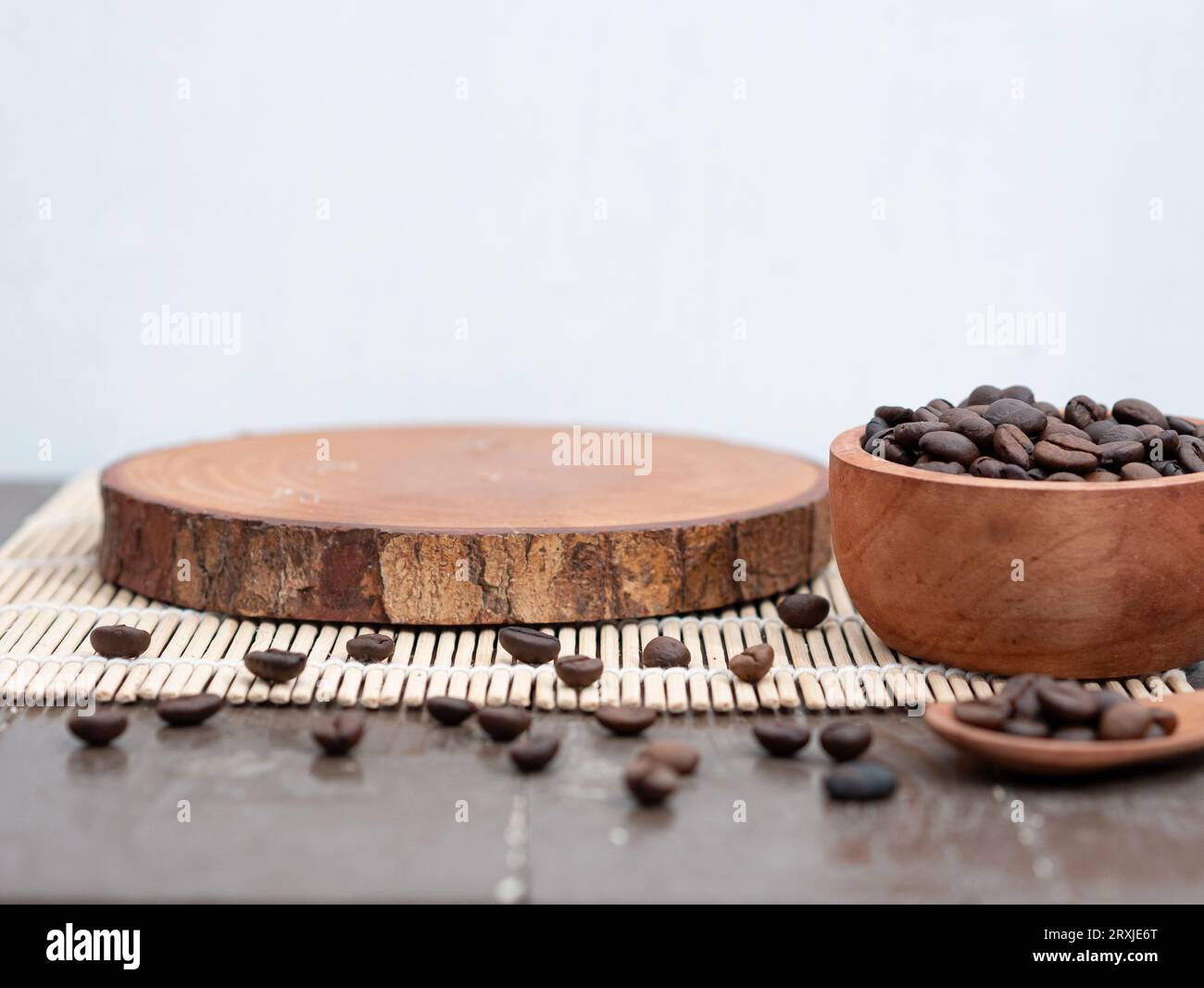 a round wooden plank and scattered coffee beans. product placement concept for coffee drinks. Stock Photo