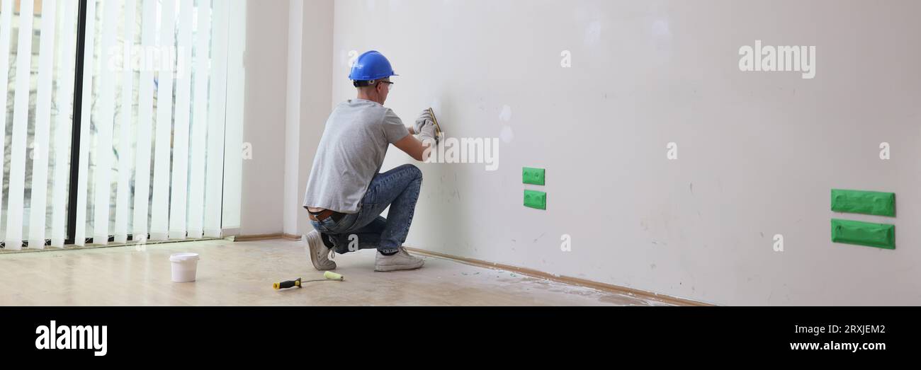 Worker in hard hat plastering wall before paint Stock Photo Alamy