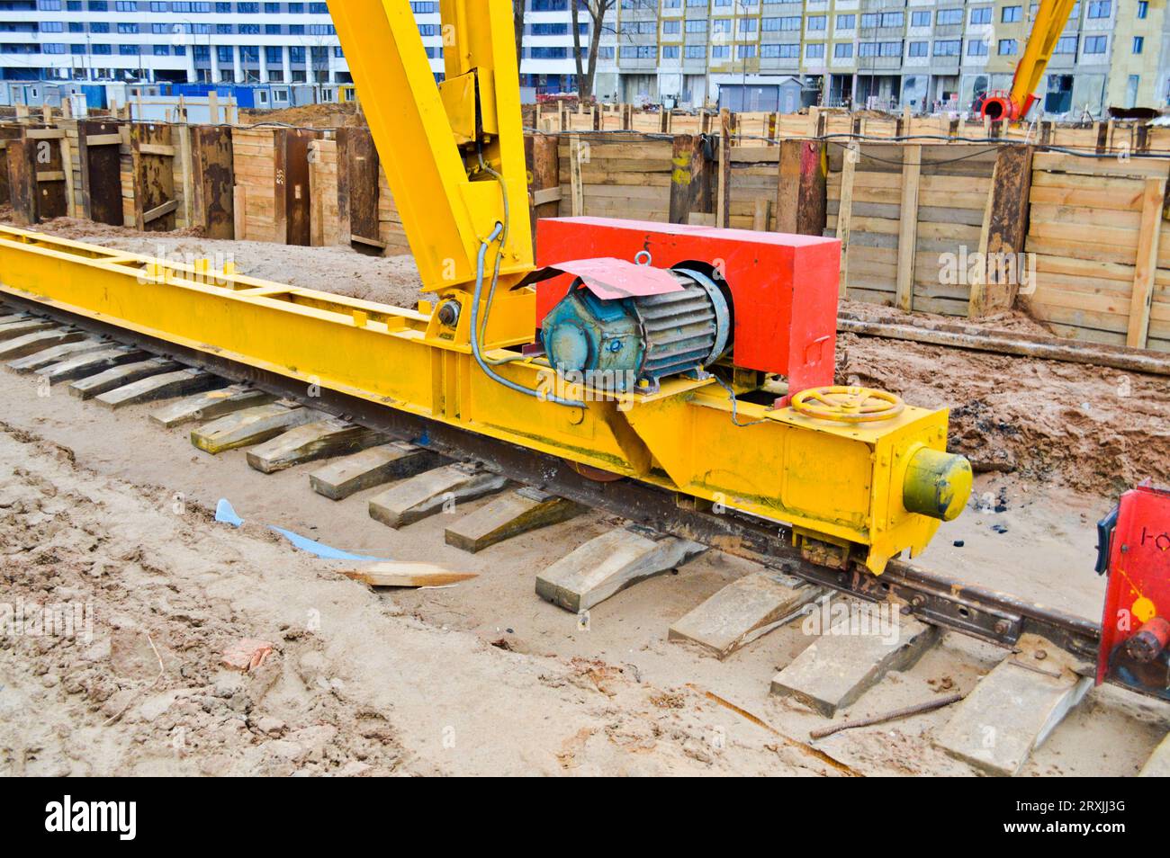 Large iron metal yellow supports on rails with wheels with an induction motor of a large construction stationary industrial powerful gantry crane of a Stock Photo