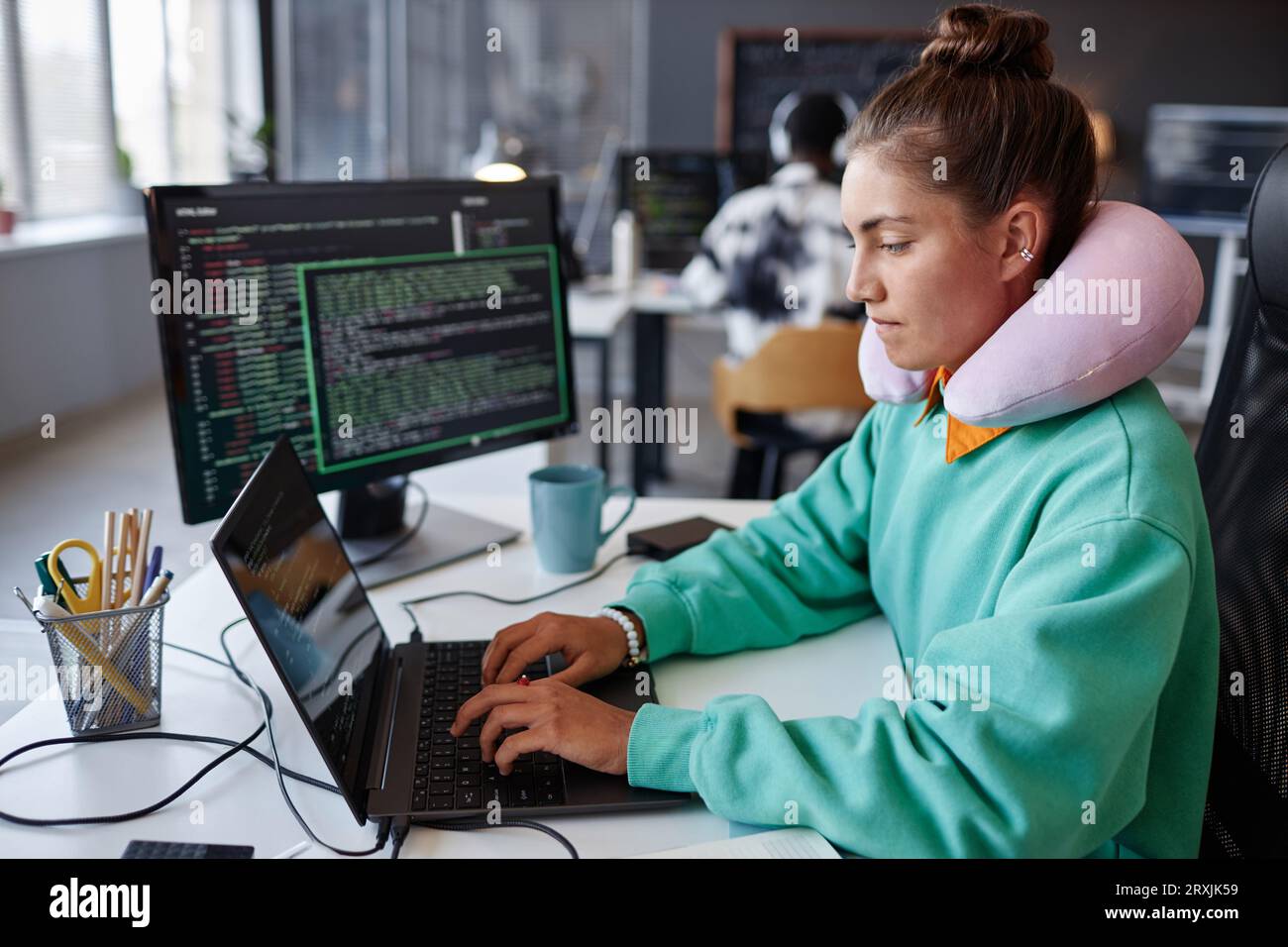 Young developer concentrating on work with security codes on laptop at her workplace in office Stock Photo