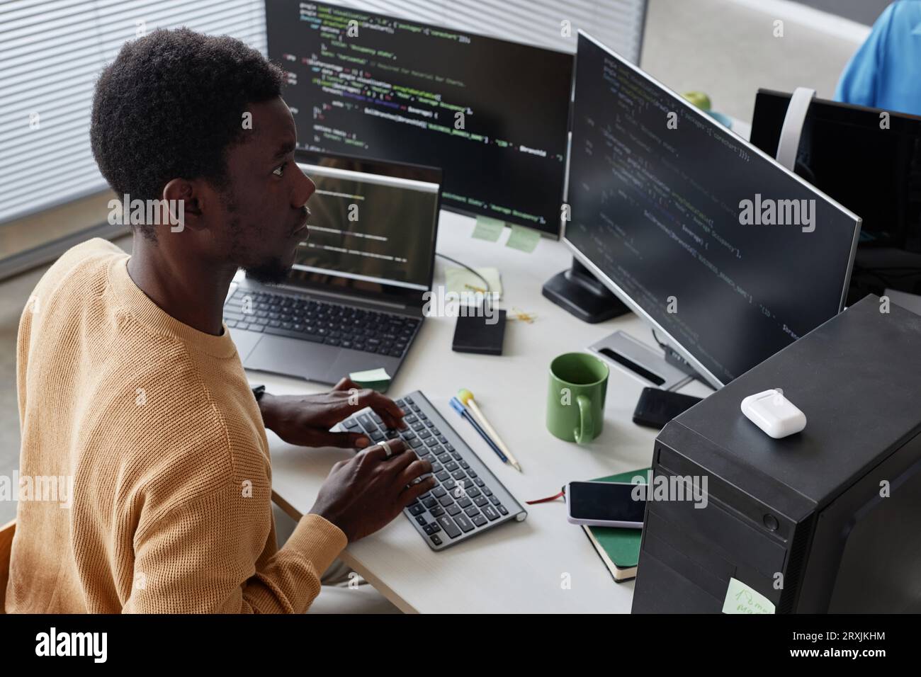Serious African American developer working with security codes on computer at his workplace Stock Photo