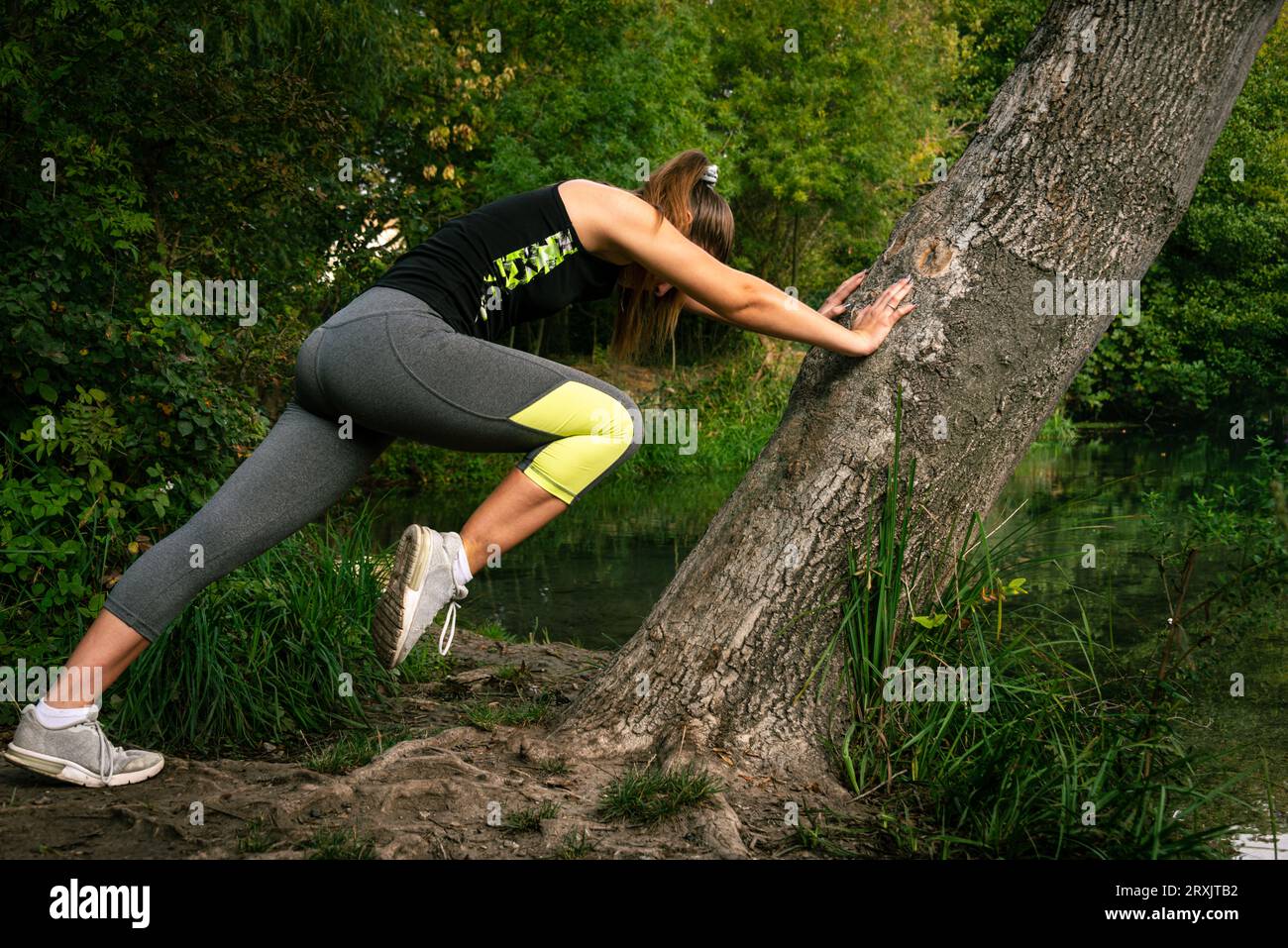 Woman stretching legs before jogging in the countryside dressed in sportswear. Fitness and lifestyle warmup ,concept. Stock Photo