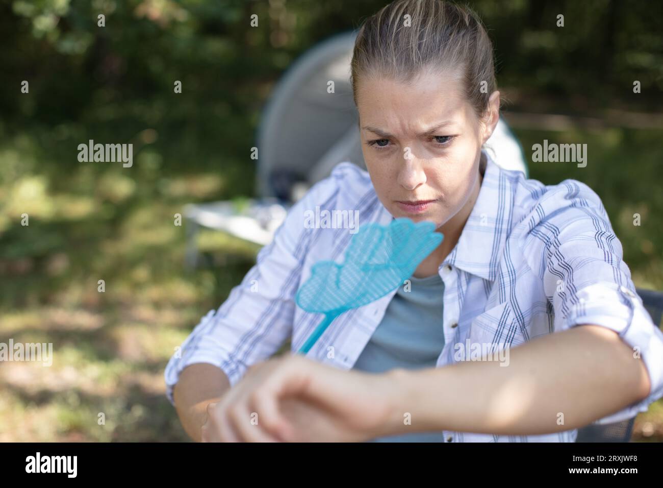 woman camper annoyed by flies Stock Photo