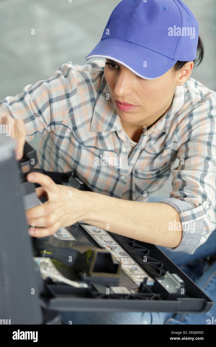 young female technician fixing printer Stock Photo
