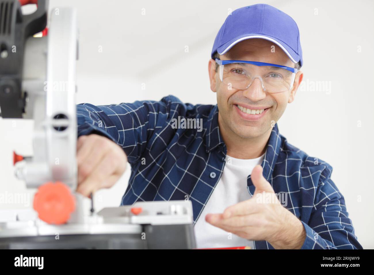 happy carpenter working on an electric buzz saw Stock Photo