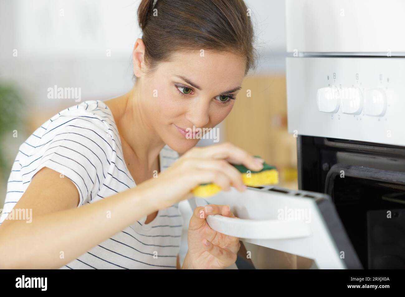 young woman washes a microwave Stock Photo