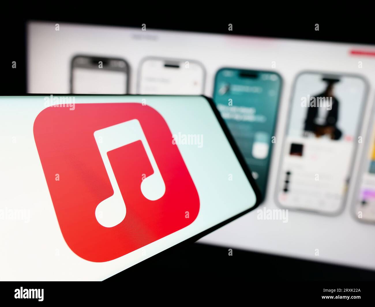 Mobile phone with logo of streaming service platform Apple Music on screen in front of company website. Focus on center-left of phone display. Stock Photo