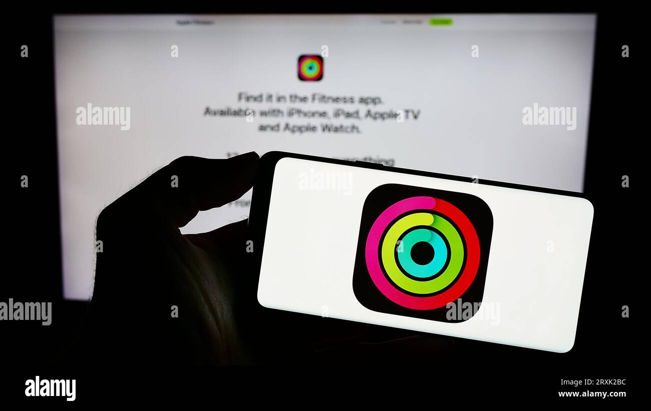 Person holding mobile phone with logo of exercise tracking app apple