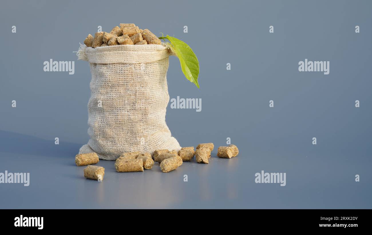 Burlap or jute bag of granulated chicken feed isolated on gray background. Closeup of poultry feed or pets healthy supplement in a bag on a studio bac Stock Photo