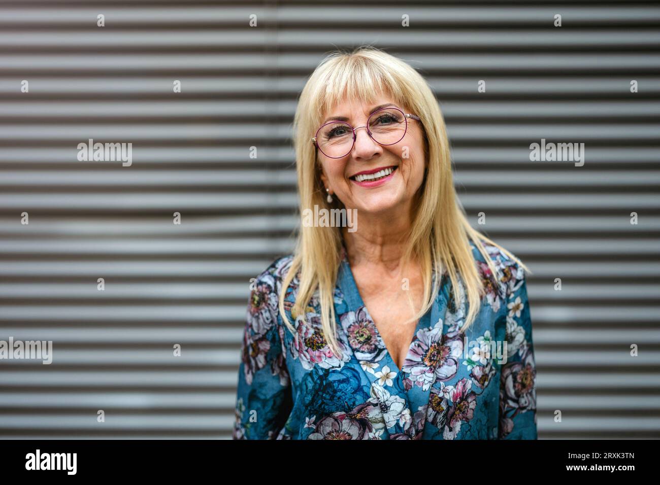 Portrait of a happy senior woman in eyeglasses standing outdoors Stock Photo