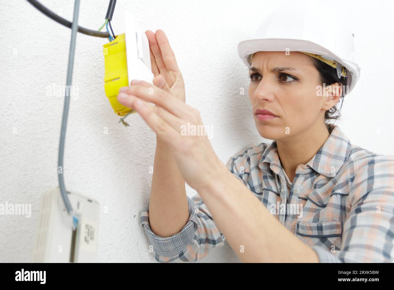 woman electrician installing switch in a new house Stock Photo