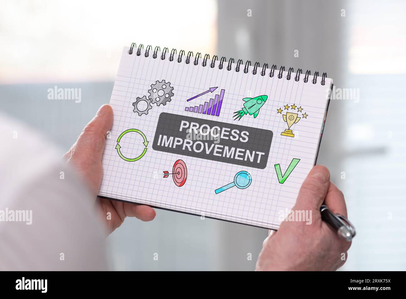 Hand holding a notepad with process improvement concept Stock Photo