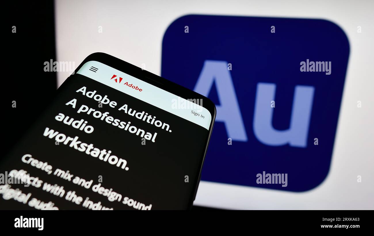 Smartphone with website of digital audio workstation Adobe Audition on screen in front of business logo. Focus on top-left of phone display. Stock Photo