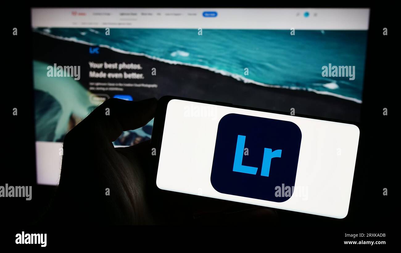 Person holding mobile phone with logo of image processing software ...