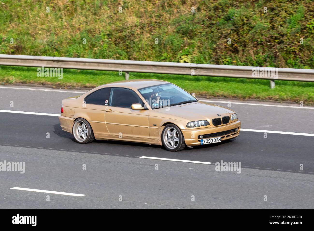2000 BMW 318I Gold saloon car Petrol 1895 cc, left hand drive 4-door sedan body; travelling at speed on the M6 motorway in Greater Manchester, UK Stock Photo